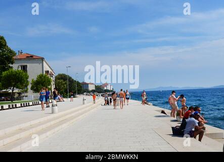 Touristen Genießen Sie den Blick auf die Adria von der Nova Riva Promenade in Zadar, Kroatien. Stockfoto