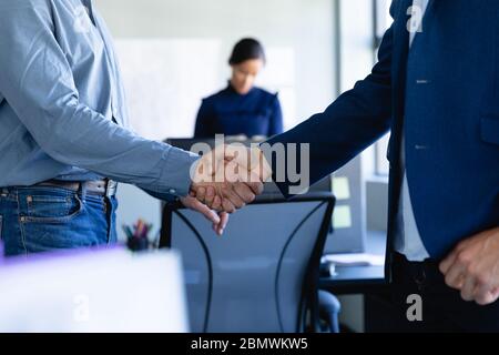 Geschäftsmann schüttelt im Büro die Hände Stockfoto