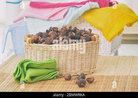 Korb voller Seifennüsse, natürliche Bio-Waschmittel und Wäsche Stockfoto