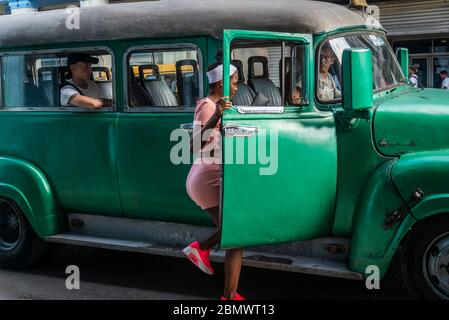 Junge Frau, die in ein Sammeltaxi auf Simon Bolivar Avenue, Havana Centro District, Havanna, Kuba Stockfoto