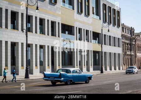 Oldtimer fahren entlang der Malecon oder Avenida de Maceo, eine breite Esplanade und Straße, die sich für 8 km entlang der Küste, Havanna, Kuba Stockfoto