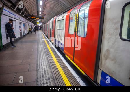 Verschwommene Londoner U-Bahn mit einigen Pendlern, die auf den nächsten Zug, London, Großbritannien warten Stockfoto