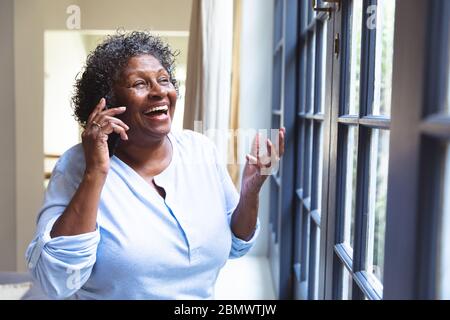 Ältere afroamerikanische Frau, die ein Telefon zu Hause während der Quarantänesperre für Coronavirus covi Stockfoto
