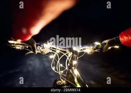 Mountainbike Lenker mit Weihnachtsbeleuchtung im Schnee Straße im Winter Nacht eingerichtet Stockfoto