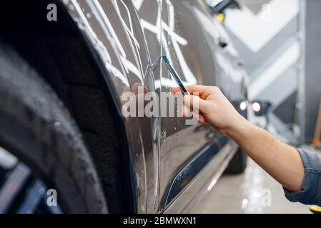 Spezialist schneidet Schutzfolie auf Autooberflächen Stockfoto