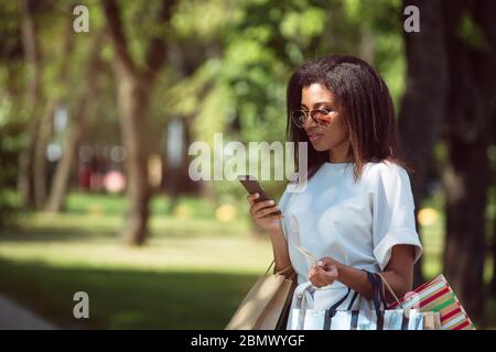 Frau hält eine Kreditkarte und mit Handy für Online-shopping Stockfoto