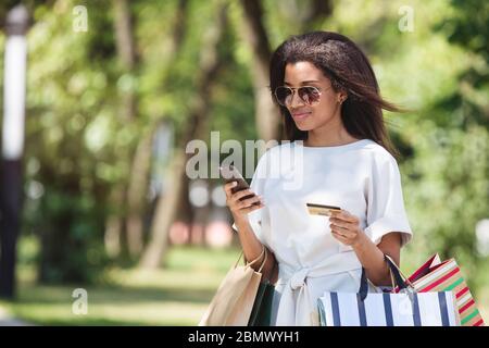 Frau hält eine Kreditkarte und mit Handy für Online-shopping Stockfoto