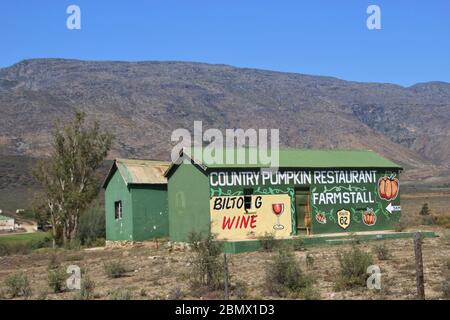 Bauernhäuser mit Werbung an der Wand neben der Landstraße, auf der Route 62, in der Karoo gemalt. Barrydale, Südafrika, Afrika. Stockfoto