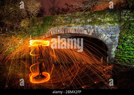 Spinnerei mit Stahlwolle an einer alten stillgesteppte Eisenbahn Brücke Stockfoto