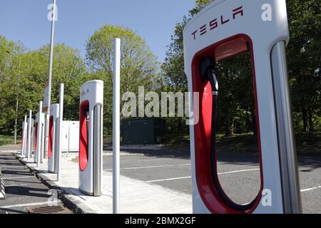 Tesla Elektronische Fahrzeugladestation an einer Tankstelle entlang der M62, Yorkshire, Großbritannien. Stockfoto