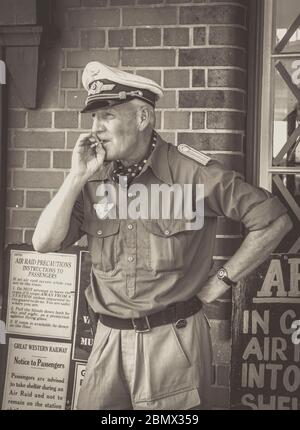 Monochrom, Schwarzweiß, Nahaufnahme des Offiziers der deutschen Luftwaffe im Vintage-Bahnhof, Severn Valley Railway Sommerveranstaltung der 1940er Jahre, Großbritannien. Stockfoto