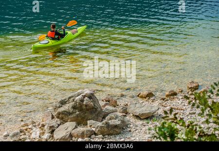 Mann Im Urlaub Genießen Kajak In Unberührten Und Sauberen See. Stockfoto