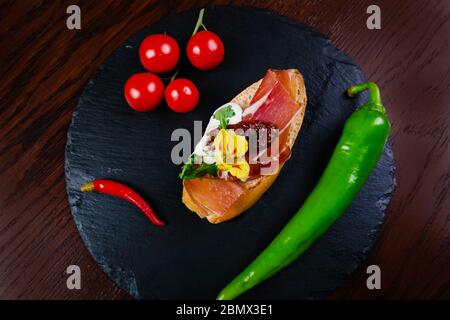 Spanische Tapas. Geröstetes Brot mit Ziegenkäse und serrano-Schinken Stockfoto