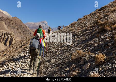 Touristen wandern in den Bergen. Touristen gehen auf einem schmalen Weg in die Berge. Himalaya, Nepal. Stockfoto