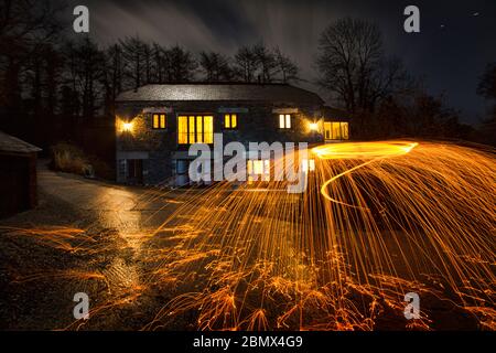 Kreatives Nachtbild mit Feuerspinning Stockfoto