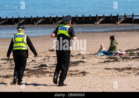 Portobello, Schottland, Großbritannien. 11 Mai 2020. Polizei patrouilliert Promenade und Strand in Portobello heute Nachmittag bei warmem, sonnigem Wetter. Sie sprachen mit der Öffentlichkeit, die am Strand oder an der Meeresmauer saßen und baten sie, sich weiter zu bewegen. Iain Masterton/Alamy Live News Stockfoto