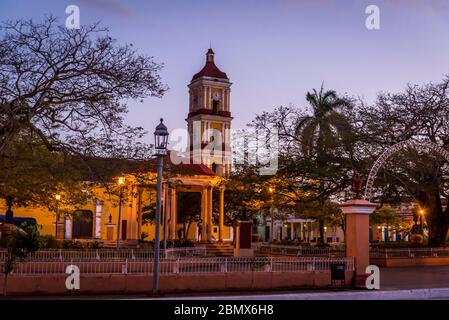 Zentraler Platz mit Musikpavillon und Glockenturm der Kirche St. Johannes der Täufer in der Abenddämmerung in einer gut erhaltenen Kolonialzeit Stadt Remedios, Kuba Stockfoto