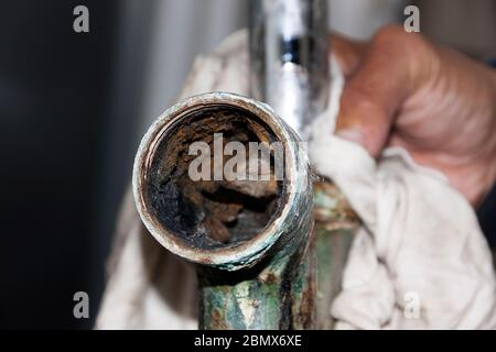 Das Innere eines korrodierten Waschbecken Rohr als Folge des Alters, hartes Wasser und Kalziumablagerungen. Stockfoto