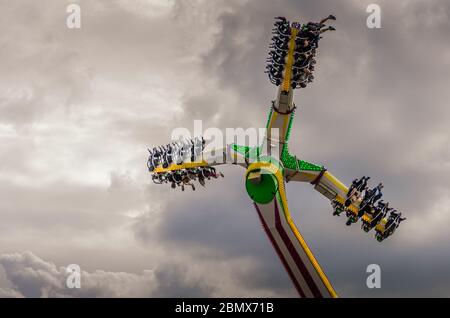 Blick auf Nervenkitzel auf einem Fairground Fahrt gegen einen dramatischen bewölkten Himmel Stockfoto
