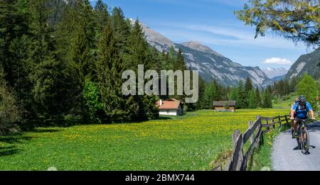 10. Mai 2020 - Vaettis, SG / Schweiz: Das Paar genießt es mit seinen E-Bikes in einer idyllischen Schweizer Alpenlandschaft zu Mountainbiken Stockfoto