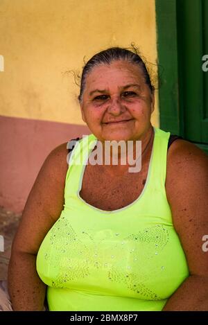 Einheimische Frau auf Treppen vor einem Haus im Kolonialzeitzentrum der Stadt, Trinidad, Kuba Stockfoto