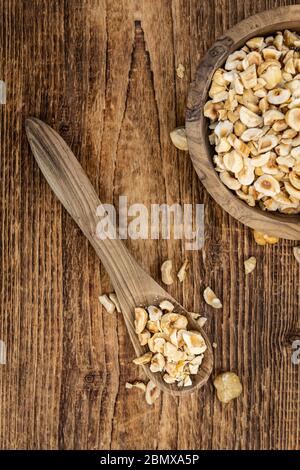 Portion frisch gehackte Haselnüsse auf einem alten Holztisch als detailreiche Nahaufnahme (selektiver Fokus) Stockfoto