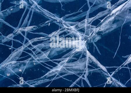 Die natürliche Textur von rissem Eis. Abbildung aus Rissen auf dem Eis des Baikalsees. Horizontal. Stockfoto