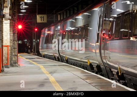 Virgin Trains Alstom Pendolino Zug am Bahnsteig 11 Crewe Bahnhof auf der Westküste Hauptlinie mit roten Eisenbahn-Gefahrenzeichen Stockfoto