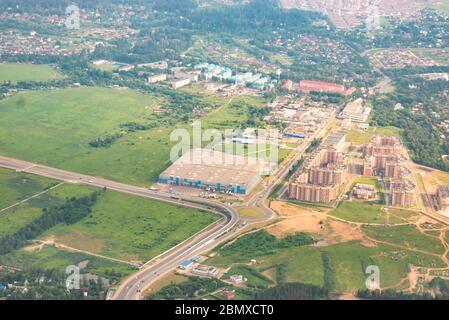 Moskau Region aus dem Fenster des Flugzeugs. Private und mehrstöckige Gebäude. Lagerkomplex in der Nähe des Flughafens. Stockfoto