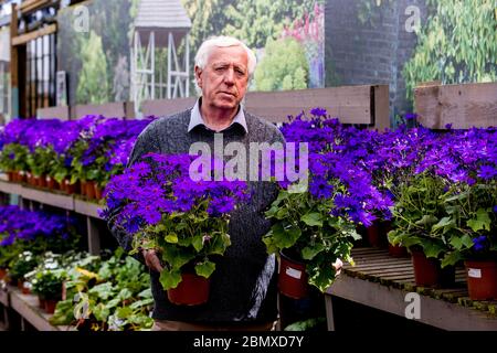 Robin Mercer, Eigentümer von Hillmount Garden Centers, hält ein Paar Topfpflanzen in seinem Zentrum in Belfast am Stadtrand. Herr Mercer hofft, dass Stormont die Sperrung des Coronavirus lockern und der Öffentlichkeit ab Mittwoch den Besuch von Gartencentern ermöglichen wird. Stockfoto