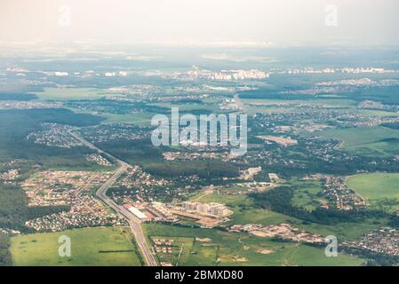Moskau Region aus dem Flugzeug-Fenster. Dörfer und Städte zwischen Wäldern und Feldern. Der Frühling ist gekommen. Stockfoto