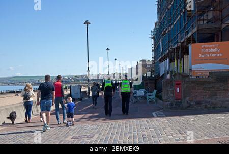 Portobello Beach, Edinburgh, Schottland, Großbritannien.11. Mai 2020. Polizeipatrouille von vier freundlichen Beamten drei männlich und ein weiblich an der ziemlich ruhigen Küste, Wir haben uns mit den wenigen Leuten, die sich am Sandstrand oder an der Promenade hinsetzten, gechattet und ihnen empfohlen, das Coronavirus von Oberflächen zu ziehen, die sie berühren, während sie am Meer sind, und ihnen zu raten, sich zu bewegen und ihre erlaubte Bewegung zu nehmen, während sie unterwegs sind. Quelle: Arch White / Alamy Live News Stockfoto