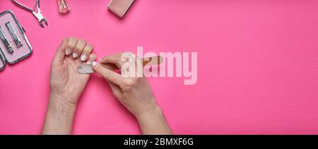 Überwucherten Nägel mit einem alten gesprungenen Gel-Politur. Selbstentfernung von altem Gel-Lack von den Nägeln mit einer Nagelfeile. Konzept der persönlichen Betreuung in der Schließung von Stockfoto