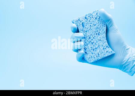 Hand in blauen Handschuh mit Schwamm Stockfoto