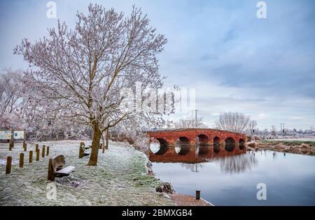 Die rote Sandsteinbrücke über den Fluss Avon bei Eckington Wharf mit einem Raureif im Winter, Worcestershire, England Stockfoto