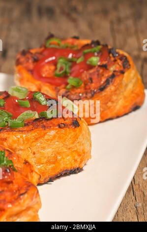 Fleisch- und Käsegebäck auf Teller im Studio füllen Stockfoto