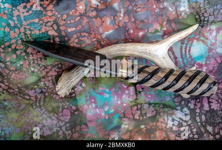 Ein einzigartiges bowie Messer mit Tropfenspitze und handgeschmiedeter damaskus-Klinge und Griff aus Myrtenholz mit dekorativen Rillen für sicheren Halt. Bokeh. Stockfoto