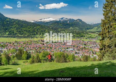 Eine hübsche ältere Frau, die mit ihrem Elektro-Mountainbike auf dem Wallraff-Trail im Nebelhorn oberhalb von Oberstdorf, Allgäu, Bayern, unterwegs ist. Stockfoto