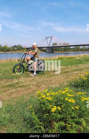 Erkunden Sie das Haus mit dem E-Bike entlang des Rheins in Deutschland Stockfoto