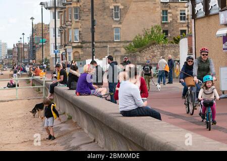 Portobello, Schottland, Großbritannien. 11 Mai 2020. Am späten Nachmittag Blick auf den beliebten Strand und die Promenade von Portobello. Trotz gelegentlicher Polizeikontrollen war die Öffentlichkeit entschlossen, sich zu entspannen und in der Sonne zu sitzen. Promenade voll mit Menschen zum Entspannen und Trainieren. Iain Masterton/Alamy Live News Stockfoto