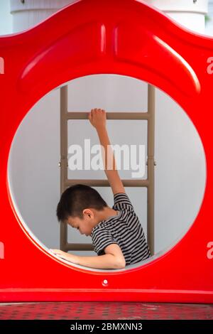 Portrait von asiatischen Jungen sind die Leiter in den Spielplatz. Stockfoto