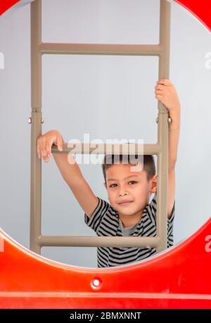 Portrait von asiatischen Jungen sind die Leiter in den Spielplatz. Stockfoto