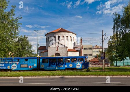 Sarajevo, Bosnien und Herzegowina - Mai 25 2019: Eine blaue Straßenbahn, die vor der Serbisch-orthodoxen Kirche der Heiligen Verklärung vorbeiführt. Stockfoto
