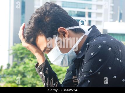 Porträt eines kranken Mannes mit medizinischer Maske. Stressiges Leben des Menschen. Stockfoto
