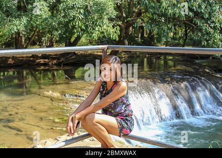 Asean-Frau und Wasser in den strom ist grün und leuchtend grünen Baum bei Kapo Wasserfall Fores Park, Chumphon in Thailand. Stockfoto