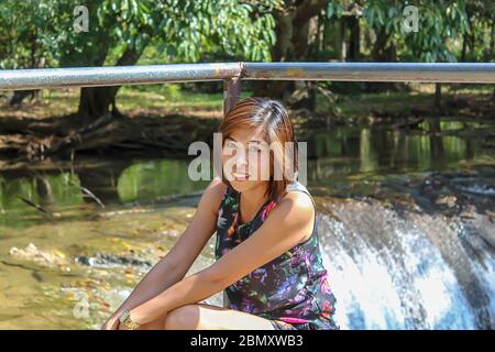 Asean-Frau und Wasser in den strom ist grün und leuchtend grünen Baum bei Kapo Wasserfall Fores Park, Chumphon in Thailand. Stockfoto