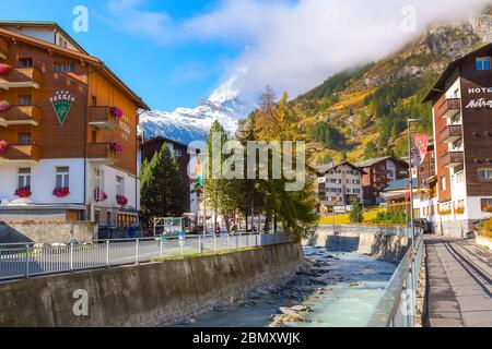 Zermatt, Schweiz - 7. Oktober 2019: Blick auf die Straße der Stadt im berühmten Skigebiet Schweizer Alpen, Fluss, Matterhorn Schneegipfel Stockfoto