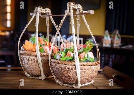 Vietnamesische Speisen werden in traditionellen Korbkörben in einem Restaurant in Hoi an serviert Stockfoto