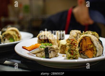 Im Miya's Sushi in New Haven, CT, USA, werden zubereitete Rollen nachhaltigen Sushi auf einem Teller serviert Stockfoto