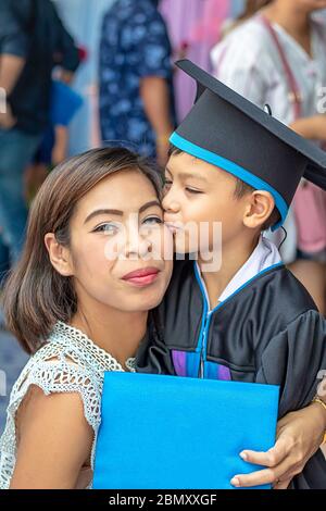 Portrait Sohn graduierte von Kindergarten küssen Mutter Stockfoto